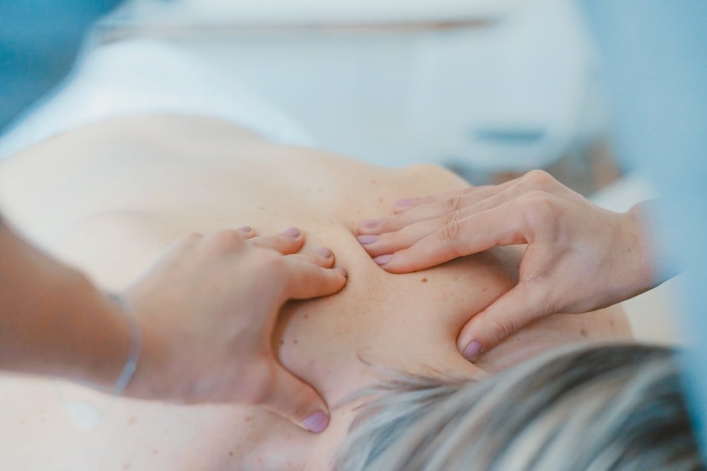Massoterapeuta trabalhando a musculatura das costas de uma paciente